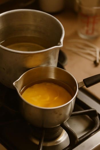 Kiçik qazanda əridilən mumu və temperatur termometri