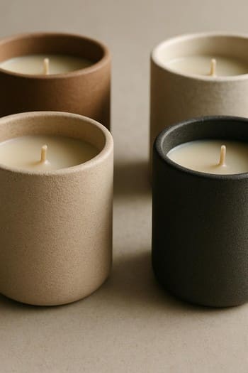 Mat şüşə şam qablarının yaxın planı və yumşaq işıq əksləri